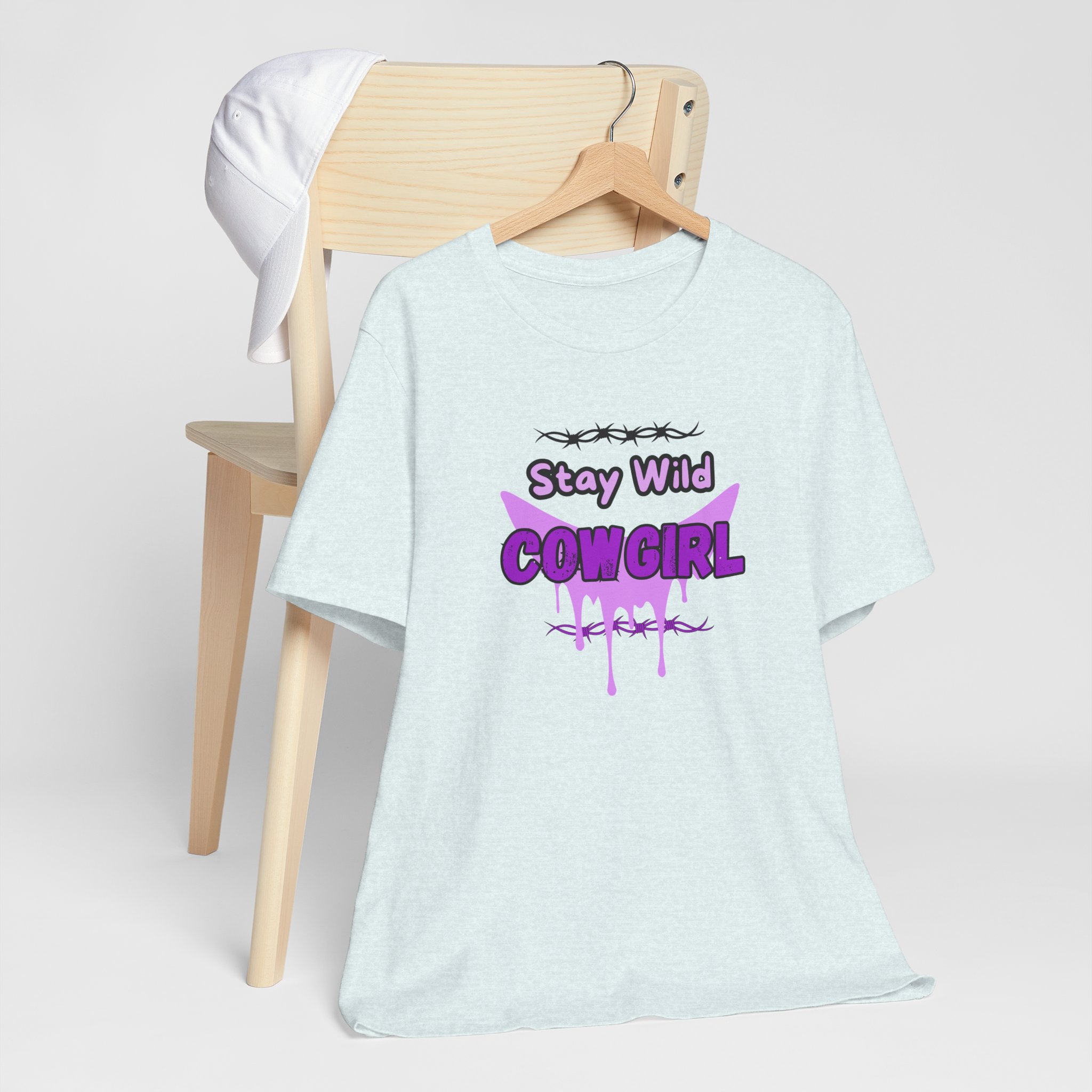 Cowgirl Western Tee featuring Stay Wild COWGIRL graphic on soft fabric displayed on a wooden chair.
