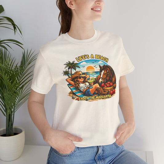 Model wearing Life's A Beach Western Tee with sunset, palm trees, and a horse, enjoying summer vibes and humor.
