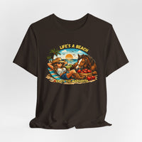 Life's A Beach Western Tee featuring a cowgirl relaxing with a horse and drinks, capturing beach vibes and humor.